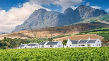 Farmhäuser mit Feldern, Berge im Hintergrund