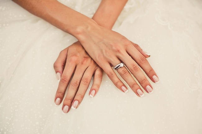Hände einer Braut mit einem Ring am von ihr aus gesehen rechten Ringfinger