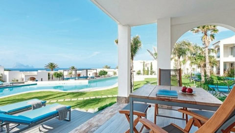 Offene Terrasse mit Gartenblick und direktem Zugang zum Pool im 7Pines Resort Ibiza – mediterrane Architektur und Palmen