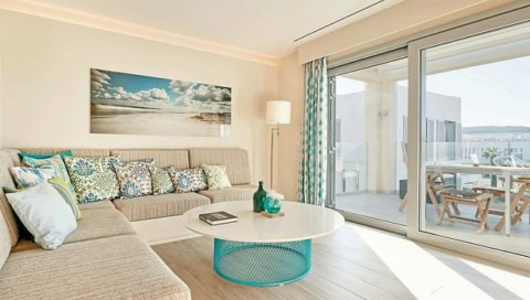 Lichtdurchfluteter Wohnbereich einer Suite mit gemütlicher Sitzecke und Balkon im 7Pines Resort Ibiza