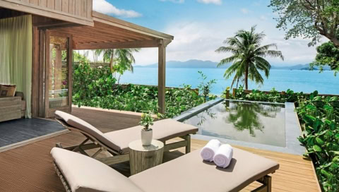 Terrasse mit Liegestühlen und privatem Pool, Meerblick im Hintergrund.