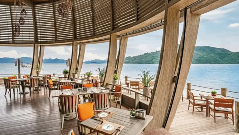 Restaurant mit Holzinterieur und Panoramablick auf das Meer.