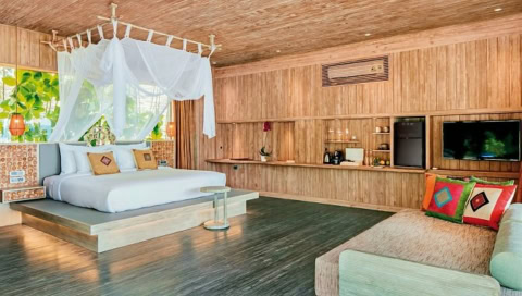 Großzügiges Zimmer mit Himmelbett, Sofa und Holzinterieur.