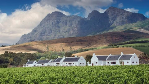 Farmhäuser mit Feldern, Berge im Hintergrund