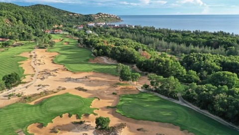 Luftaufnahme eines weitläufigen Golfplatzes mit Meer im Hintergrund