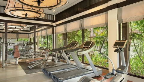 Modernes Fitnessstudio mit Laufbändern, Hanteln und Blick ins Grüne