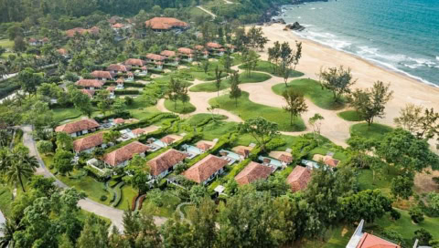 Luftaufnahme der weitläufigen Hotelanlage mit Villen, Gartenanlagen und Strand