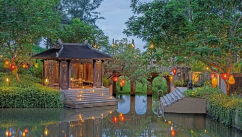 Stimmungsvolles Pavillon am Wasser mit Laternen im Garten