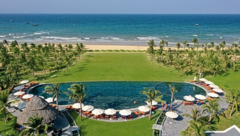 Großer Pool mit Sonnenschirmen, grüner Liegewiese und Meerblick