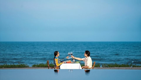 Paar beim romantischen Dinner am Strand mit Blick auf das Meer