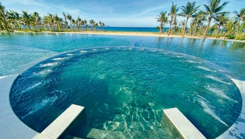 Runder Whirlpool-Bereich im Pool mit Aussicht auf Strand