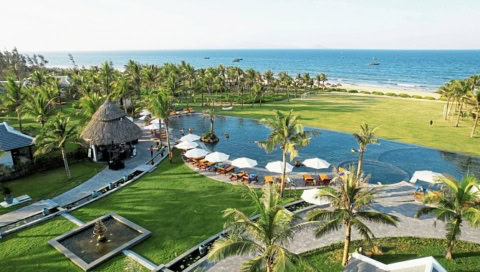 Poolanlage mit Liegen, Palmen und direktem Zugang zum Strand