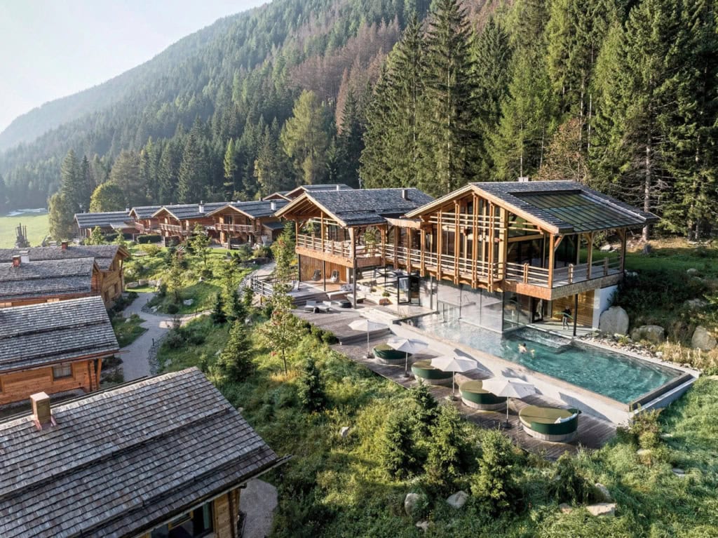 Chaletdorf Valsegg mit Holzhäusern, Poolbereich, Sonnenterrasse und Waldkulisse in den Bergen