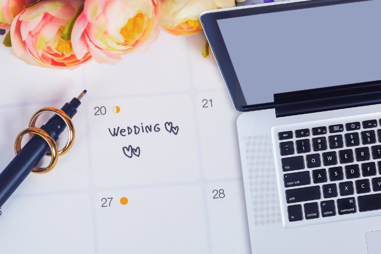Ein Kalender mit eingetragenem Hochzeitsdatum, neben einem Laptop