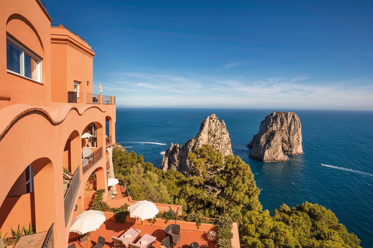 Balkon des Hotel Punta Tragara mit Blick auf das tiefblaue Meer und die Faraglioni-Felsen vor Capri