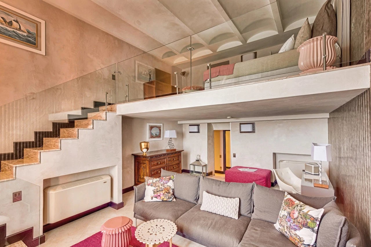 Großzügiges Doppelzimmer im Hotel Punta Tragara mit Wohnbereich, Schlafebene, Treppe und hellen Farben