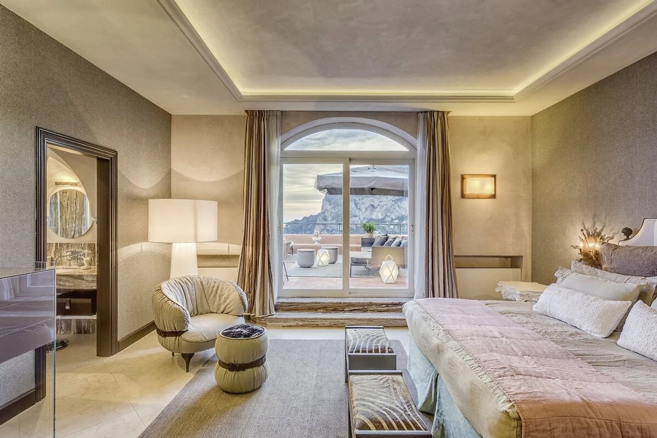 Helles Doppelzimmer im Hotel Punta Tragara mit Terrasse, Meerblick, elegantem Bett und sanften Naturtönen