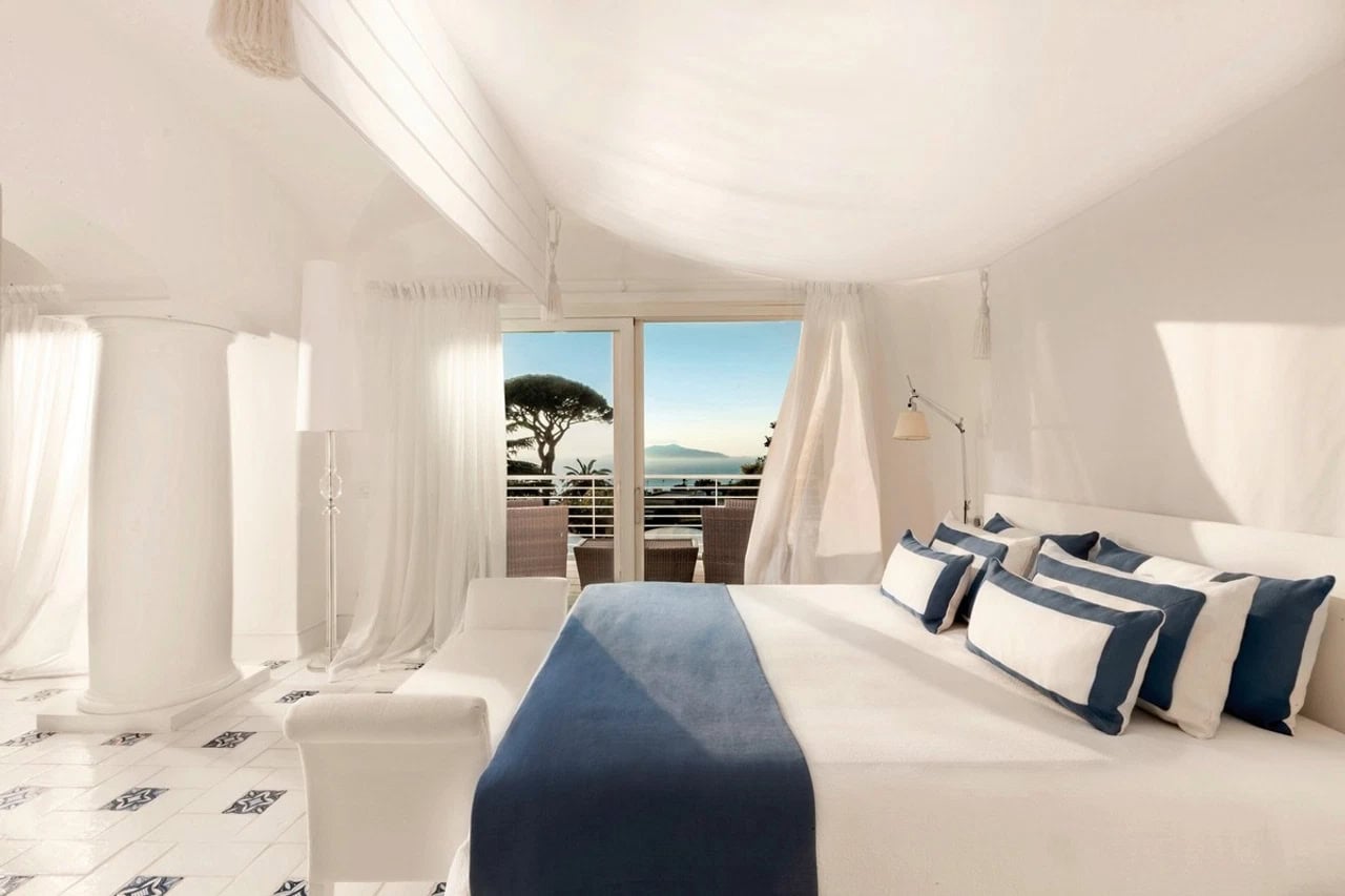 Helles Doppelzimmer im Jumeirah Capri Palace mit Meerblick, Balkon, weißen Stoffen und blauen Akzenten