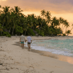 Ein schwules Paar läuft Hand in Hand an einem Strand entlang.