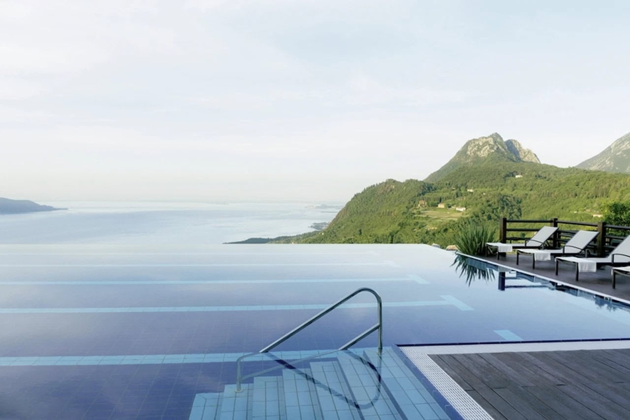 Außenpool des Lefay Resort & Spa Lago di Garda mit Infinity-Blick auf See, Berge und grüne Hänge