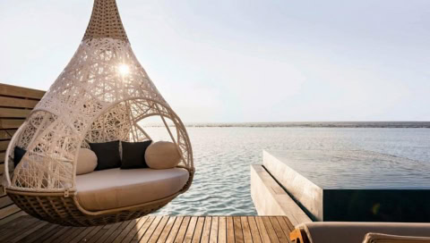 Hängende Sitzecke auf Pavillonveranda mit Meerblick.