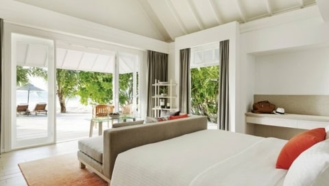 Suite mit Bett und Sofa am Fußende des Bettes.