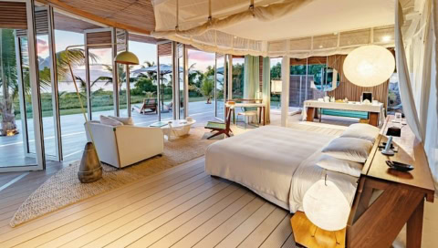 Hotelzimmer mit großer Fensterfront und hellen Möbeln