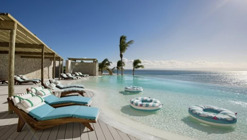 Pool mit Sonnenliegen und Meerblick