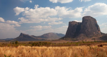 Spektakuläre Granitfelsen und Inselberge in Mosambik mit goldgelbem Gras im Vordergrund.