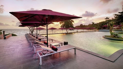 Pool mit Liegen bei Sonnenuntergang