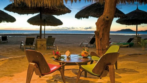 Tische und gemütliche Sessel direkt am Strand.