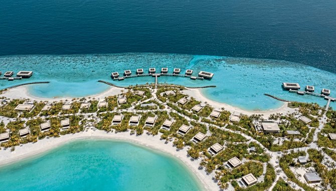 Luftaufnahme des Patina Maldives Fari Islands mit Strandvillen und Overwater-Villen in türkisfarbener Lagune