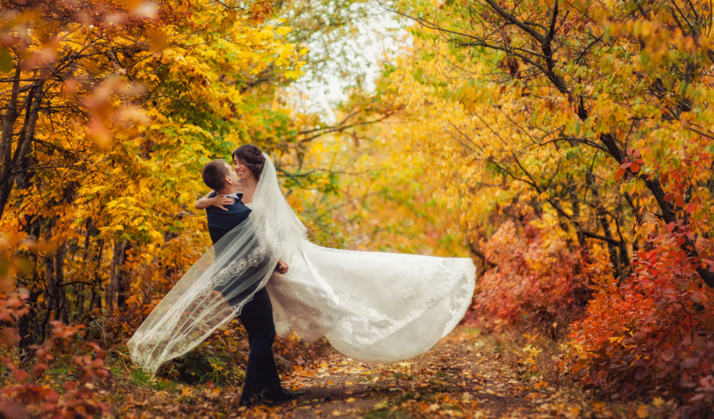 Ein Brautpaar in einem bunten Herbstwald.