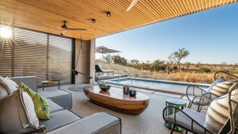 Hotelzimmer mit großer Fensterfront in die Landschaft