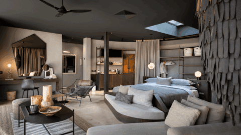 Modernes, offenes Schlafzimmer mit stilvoller Einrichtung und gemütlicher Sitzecke