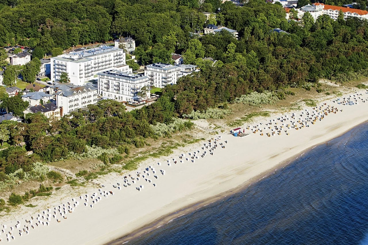 Luftaufnahme des Steigenberger Grandhotel & Spa Heringsdorf nahe der Ostsee mit Hotelgebäuden, Strand, Dünenlandschaft und vielen Strandkörben