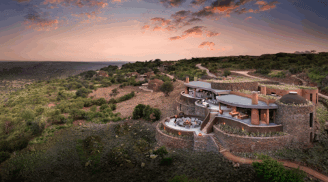 Luftaufnahme der Suyian Lodge inmitten der grünen Hügellandschaft Kenias bei Sonnenuntergang