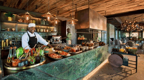 Offene Küche mit Koch und frischem Frühstücksbuffet aus regionalen Zutaten