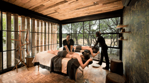 Spa-Raum mit Panoramafenstern, Massagebetten und Blick in die Natur