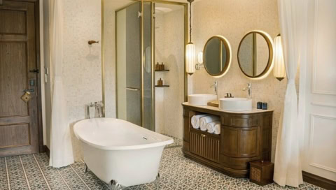 Badezimmer mit Badewanne, zwei Spiegeln und Dusche