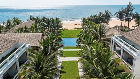 Hotelanlage mit Pool und Blick auf den Strand im Hintergrund
