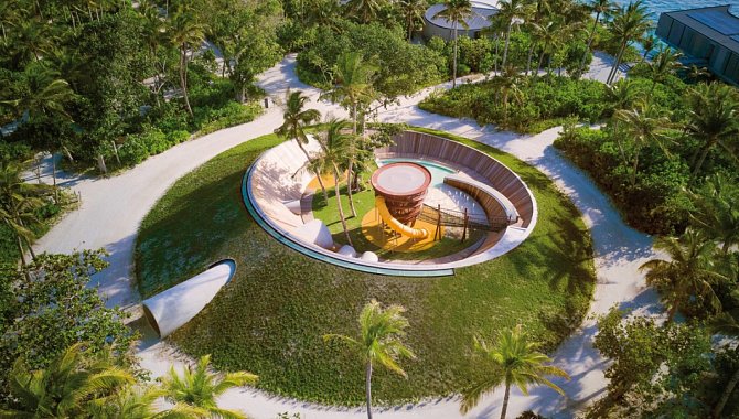 Modern gestalteter Spielbereich im Außenbereich des Resorts mit kreisförmigem Design und tropischer Umgebung