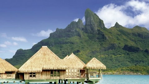 Hotelgebäude auf dem Wasser mit Insel im Hintergrund