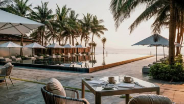 Frühstückstisch auf einer Terrasse mit Blick auf den Infinity-Pool und das Meer.