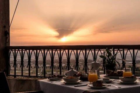 Balkon mit Blick über die Landschaft und gedecktem Frühstückstisch